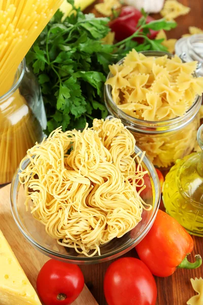 Pasta with oil, cheese and vegetables on wooden table close-up — Stock Photo, Image