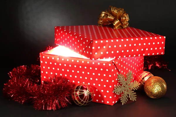 Caja de regalo con luz brillante sobre fondo gris oscuro — Foto de Stock