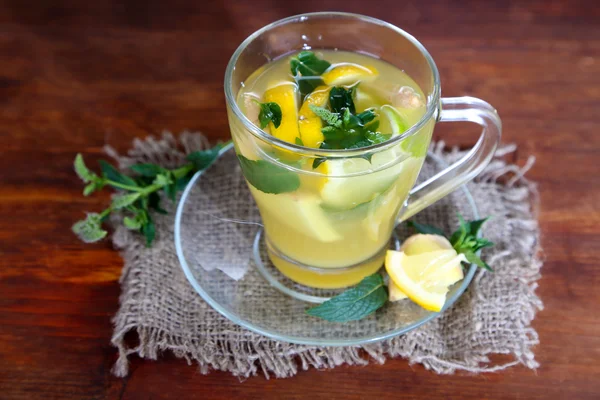 Tasse Tee mit Ingwer auf Sacktuch auf Holztisch — Stockfoto