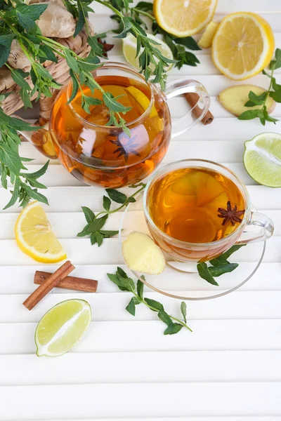 Hervidor de agua y taza de té con jengibre en la mesa de madera — Foto de Stock