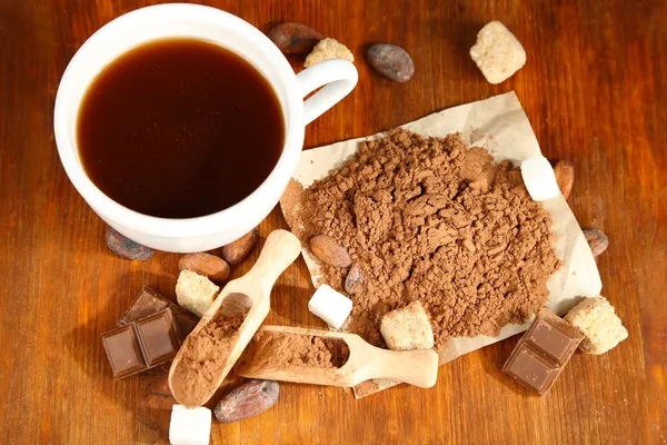 Cacao en taza y polvo de coca en mesa de madera — Foto de Stock