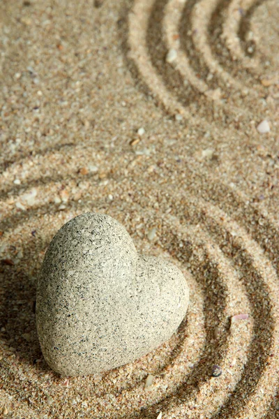 Grey zen stone in shape of heart, on sand background — Stock Photo, Image