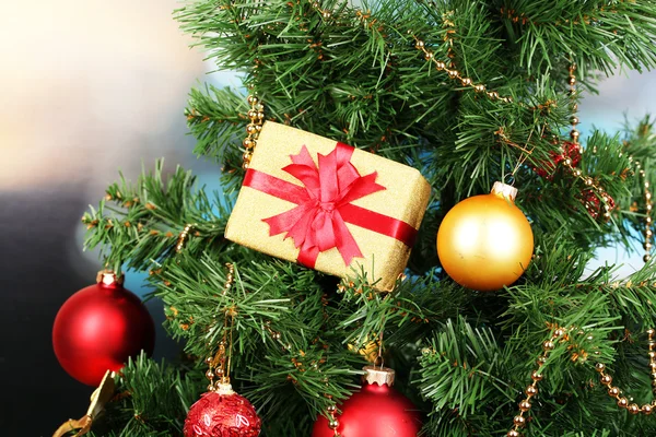 Gift on Christmas tree on room background — Stok fotoğraf