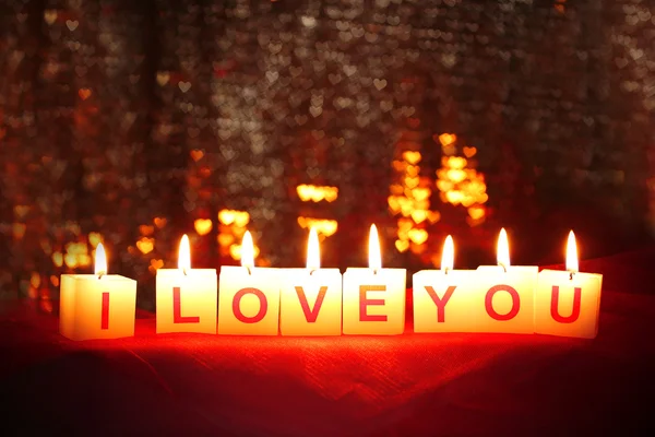 Candles with printed sign I LOVE YOU,on blur lights background — Stock Photo, Image