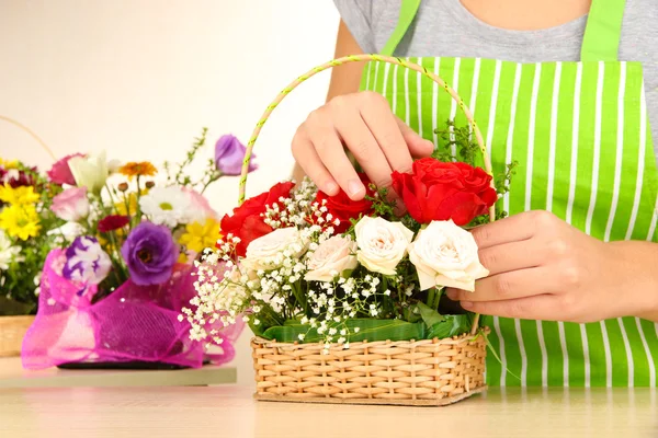 Floristería hace ramo de flores en canasta de mimbre — Foto de Stock