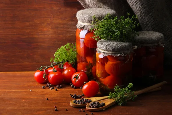 Läckra konserverad och färska tomater på träbord — Stockfoto