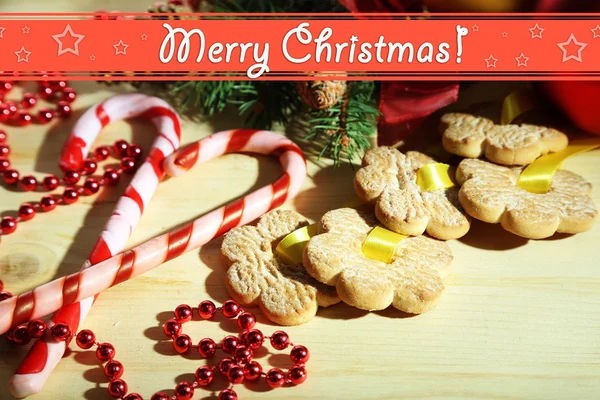 Biscoitos em fitas com decorações de Natal em mesa de madeira — Fotografia de Stock