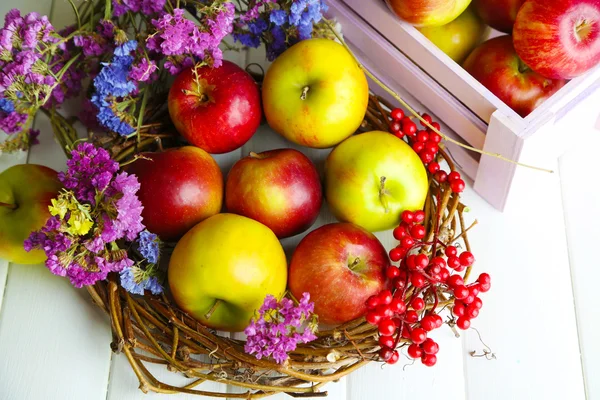 Saftige Äpfel in Schachtel auf weißem Holztisch — Stockfoto