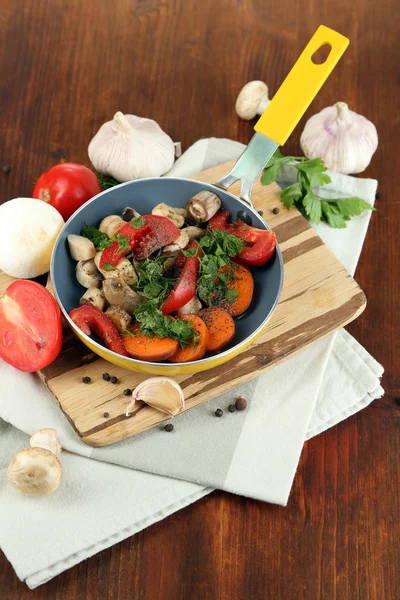 木製のテーブルのクローズ アップで鍋で新鮮な野菜をスライス — ストック写真