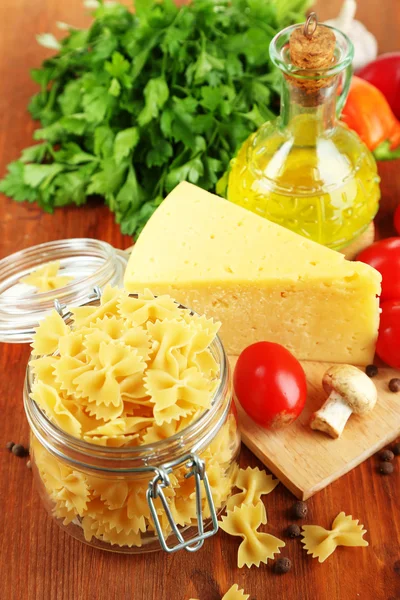 Pasta with oil, cheese and vegetables on wooden table close-up — Stock Photo, Image