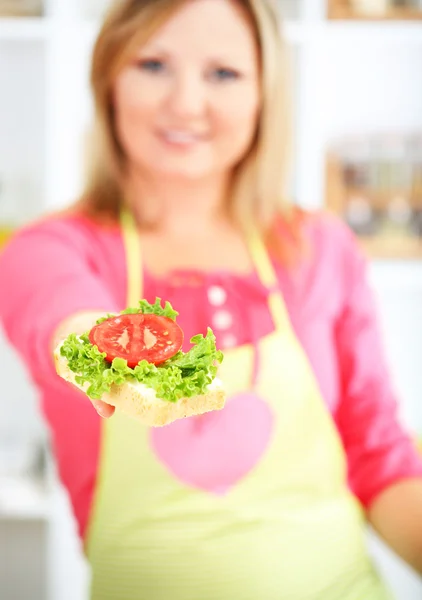 Feliz mujer sonriente en la cocina preparando sándwich —  Fotos de Stock