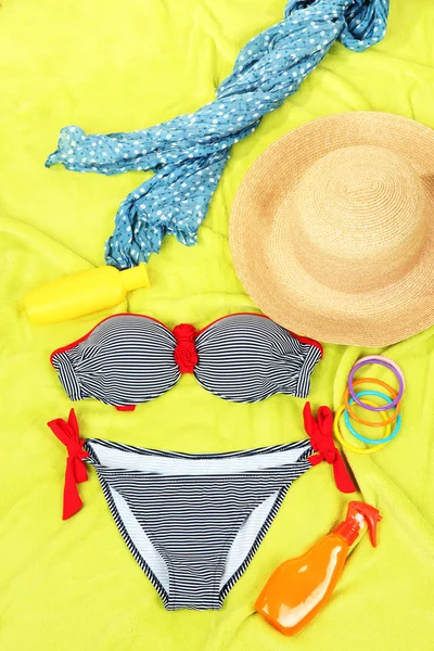 Swimsuit and beach items on bright background — Stock Photo, Image