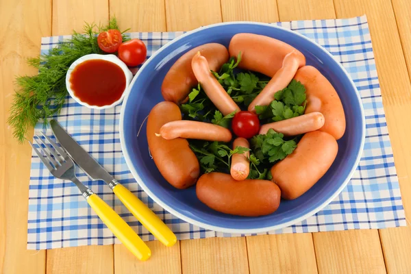 Salsicha, verduras, tomate na placa na mesa de madeira — Fotografia de Stock