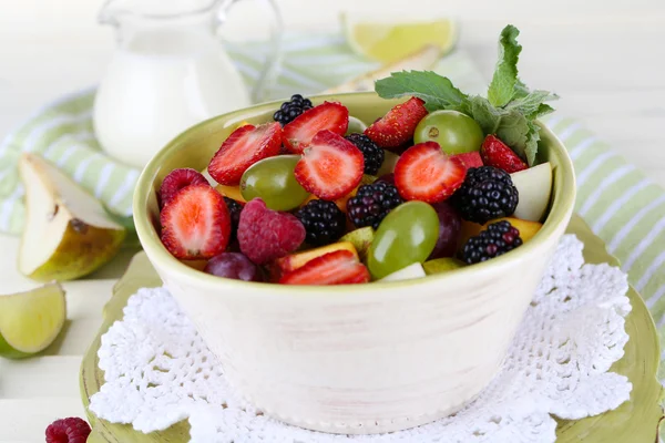 Insalata di frutta in piatti su tavolo di legno vicino a tovagliolo — Foto Stock