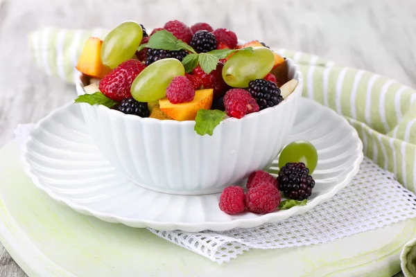 Ensalada de frutas en tazón, sobre fondo de madera —  Fotos de Stock