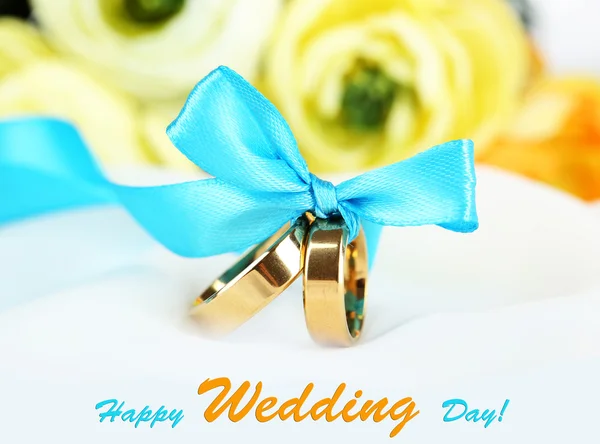 Wedding rings tied with ribbon on white fabric background — Stock Photo, Image