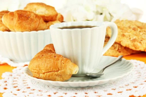 Tasty croissants and cup of coffee on table close-up — Stock Photo, Image