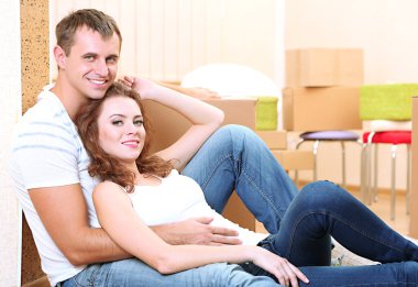 Oda arka plan üzerinde yeni ev kutuları ile genç bir çift