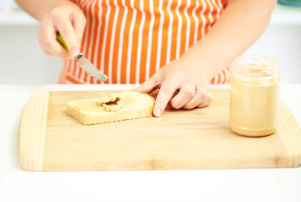 Glücklich lächelnde Frau in der Küche beim Zubereiten von Sandwich, Nahaufnahme — Stockfoto