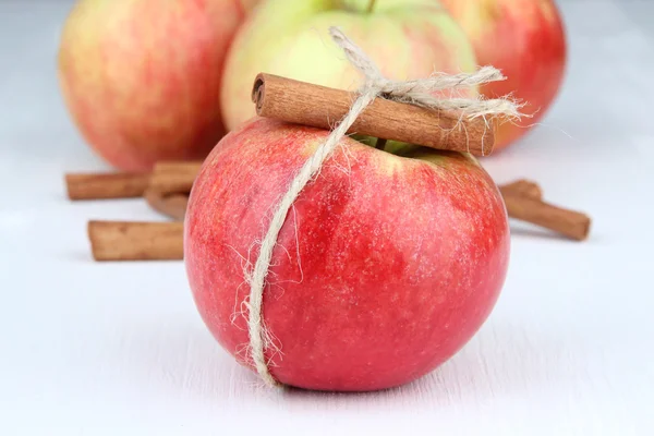 Pommes mûres avec bâtonnets de cannelle isolés sur blanc — Photo