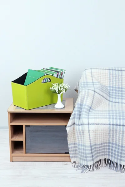 Revistas y carpetas en caja verde sobre mesita de noche en la habitación — Foto de Stock