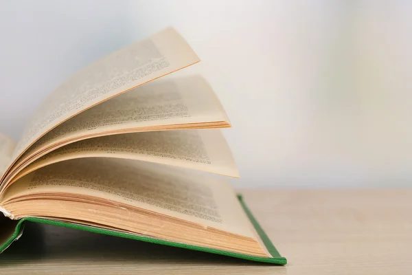 Libro abierto sobre mesa de madera sobre fondo brillante —  Fotos de Stock