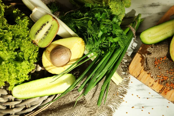 Legumes e frutas verdes frescos, sobre fundo de madeira — Fotografia de Stock