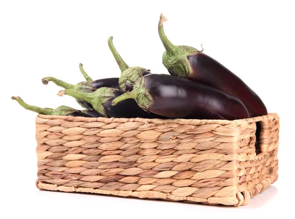 Verse aubergines in rieten mand geïsoleerd op wit — Stockfoto