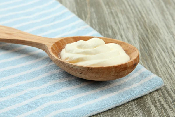 Sour cream in spoon on table close-up — Stock Photo, Image