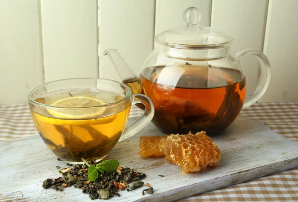 Cup en theepot van groene thee met honing op tafel op houten achtergrond — Stockfoto