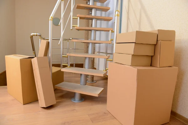 Montón de cajas de cartón cerca de escaleras: concepto de casa móvil — Foto de Stock