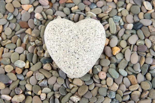 Corazón sobre pequeñas piedras marinas, de cerca — Foto de Stock