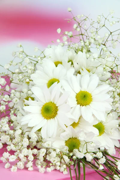 Hermosas flores en la mesa sobre fondo brillante — Foto de Stock