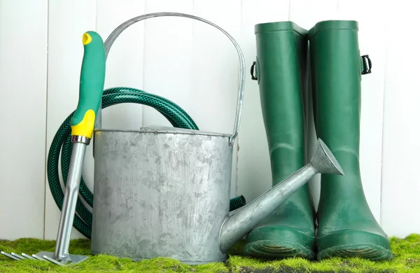 Tuingereedschap op gras op houten achtergrond — Stockfoto