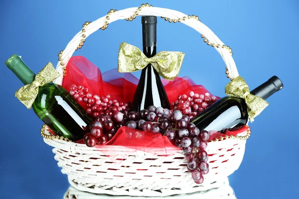 Cesto regalo con vino su sfondo blu — Foto Stock