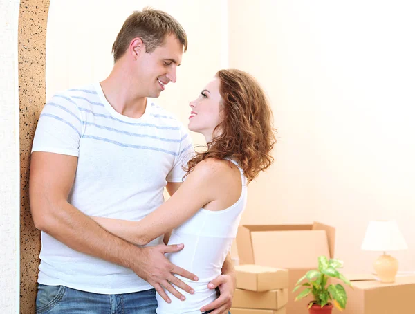 Jovem casal em nova casa no fundo do quarto — Fotografia de Stock