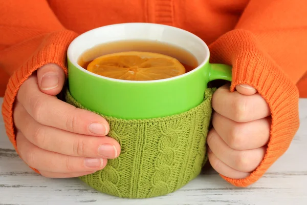 Tassen mit Stricksachen darauf auf Holztisch aus nächster Nähe — Stockfoto