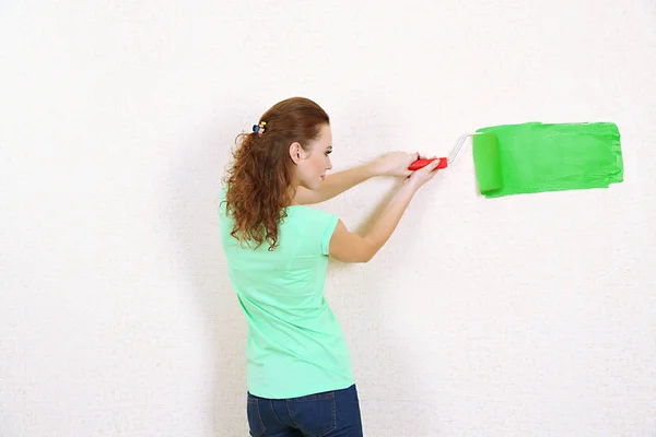 Jeune femme peint mur dans un nouvel appartement — Photo