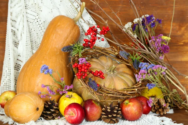 Composizione autunnale di mele, zucche, fiori e rami secchi su tavolo di legno su fondo di legno — Foto Stock