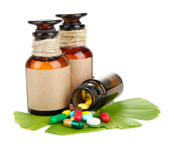 Ginkgo biloba hojas y frascos de medicamentos con pastillas aisladas en blanco — Foto de Stock