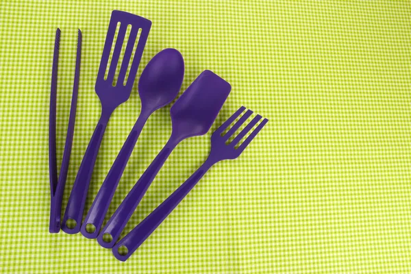 Plastic kitchen utensils on fabric background — Stock Photo, Image