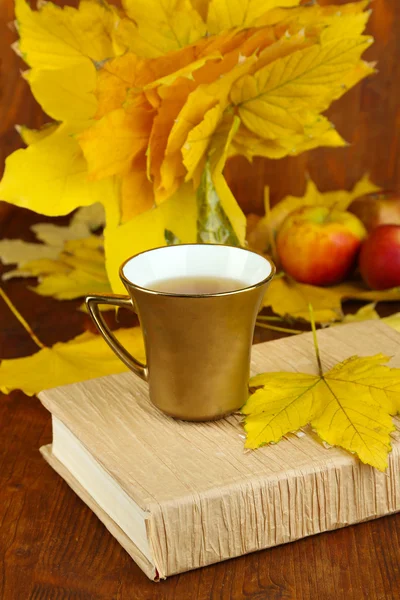 Autumn leaves, cup and book on wooden table close-up — Stock Photo, Image