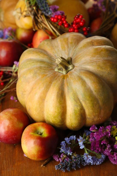 Herbstliche Komposition aus Äpfeln, Kürbissen, Blumen und trockenen Zweigen auf Holztisch in Großaufnahme — Stockfoto