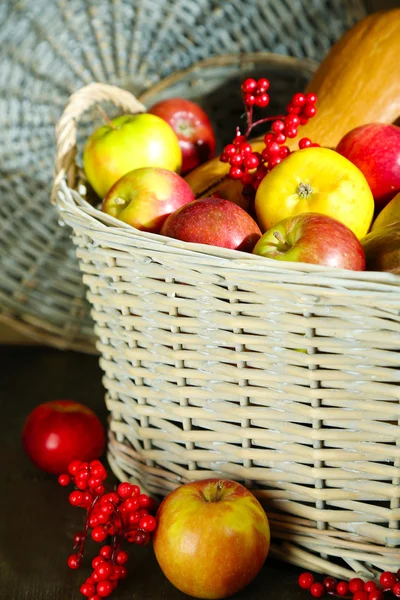 Saftige Äpfel und Kürbis im Holzkorb auf dem Tisch in Großaufnahme — Stockfoto