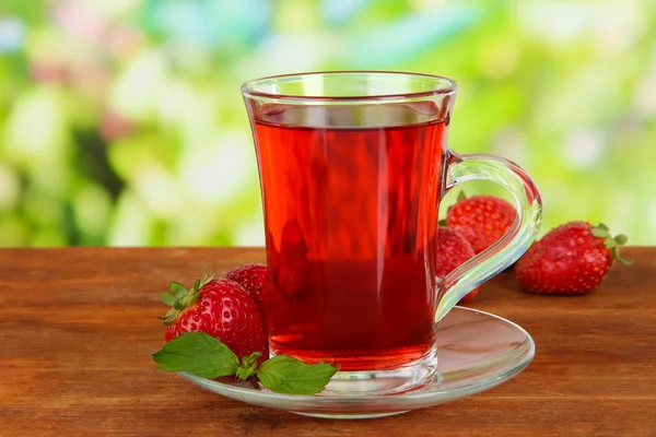 Delicioso té de fresa en la mesa sobre fondo brillante — Foto de Stock