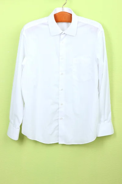 Male shirt on wooden hanger on wall background — Stock Photo, Image