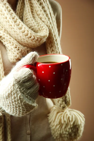 Female hands with hot drink, on color background — Stock Photo, Image