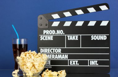 Film Klaket, cola ve mavi arka plan üzerinde patlamış mısır