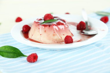 Panna cotta ahşap zemin üzerinde frambuaz sos ile
