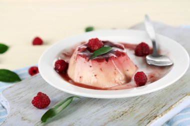 Panna cotta ahşap zemin üzerinde frambuaz sos ile